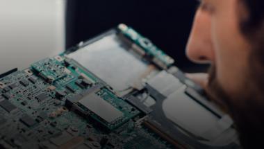 Male software developer looking at circuit board